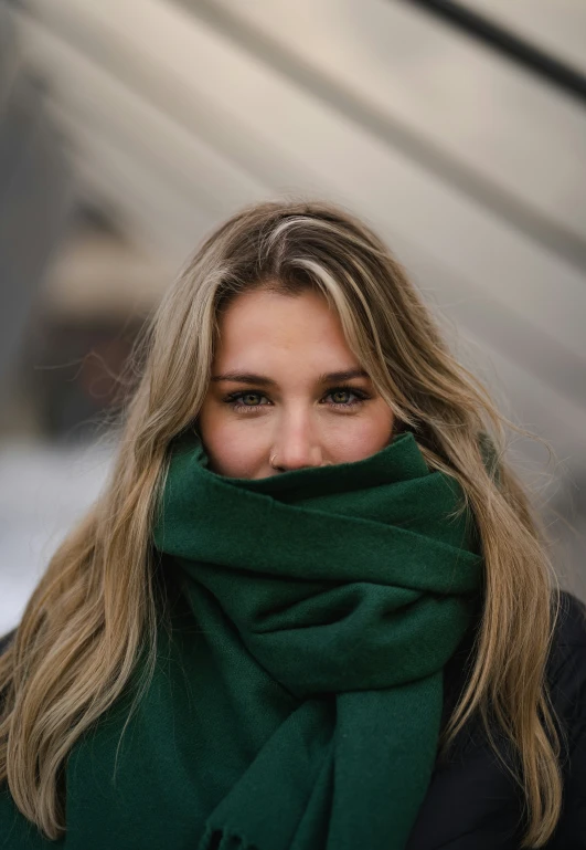 a woman in a green scarf is looking over her shoulder