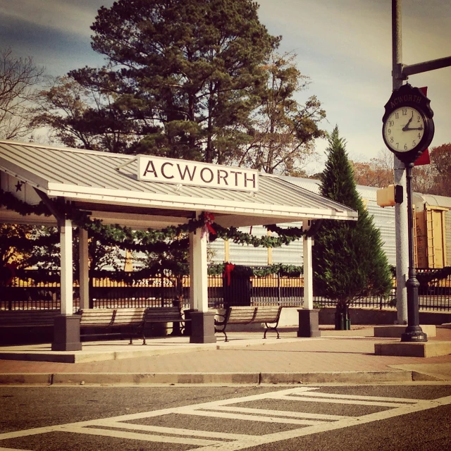 a clock is on the corner of an empty sidewalk