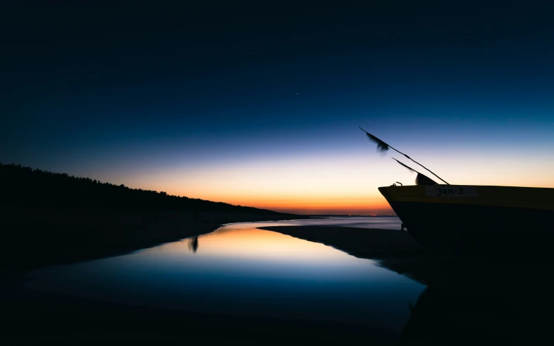 a small boat sits docked in the middle of a beach