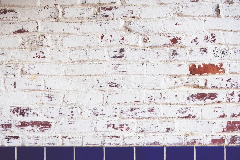 a white and blue brick wall in front of a blue tiled floor