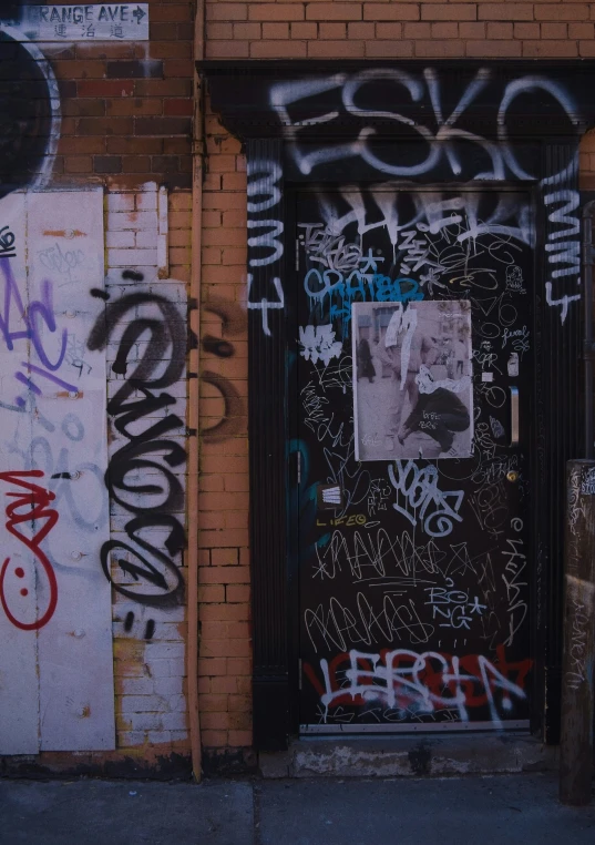 the door is covered with graffiti next to the wall