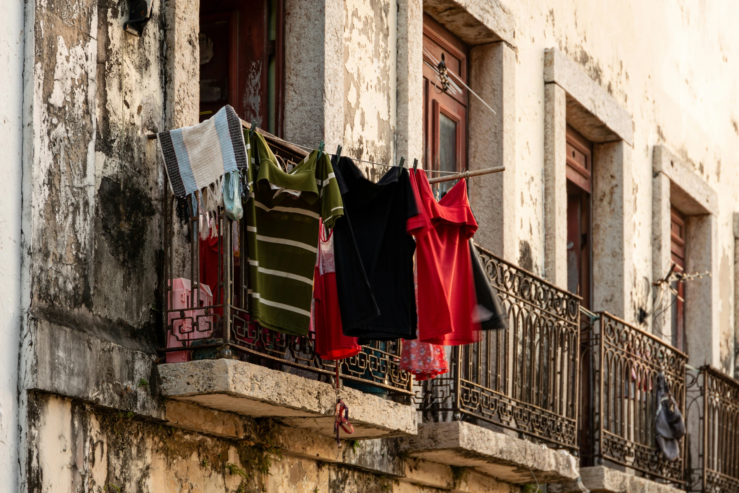 several clothes hung to dry on the balcony and in front of the windows