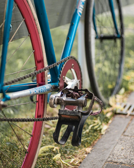 blue bicycle  to a post next to a sidewalk