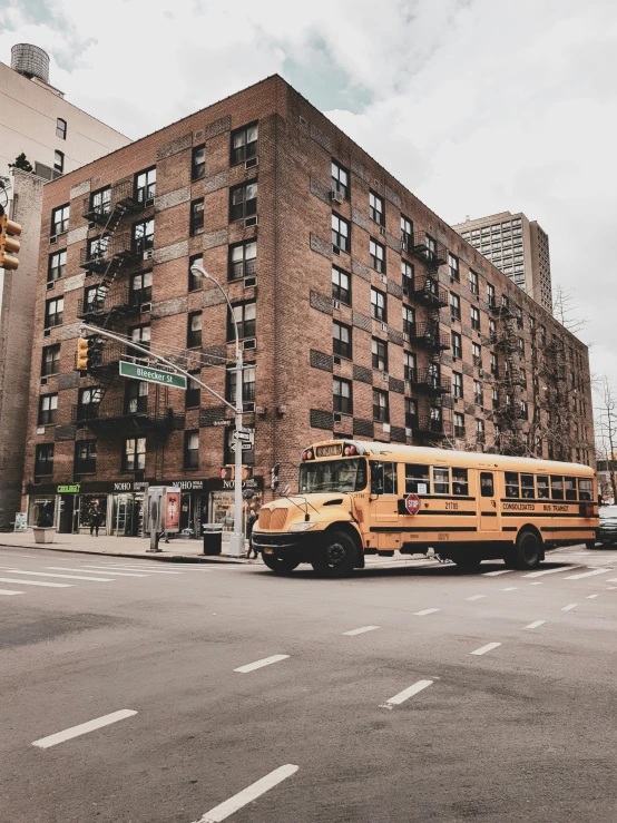 yellow school buses are driving down the street