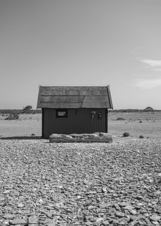 an outhouse sitting in the middle of a large desert