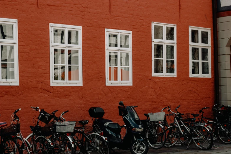 several bikes are parked next to each other in front of a red building