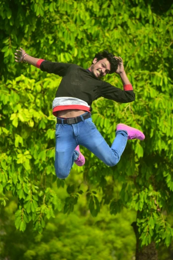a person in jeans jumps up into the air
