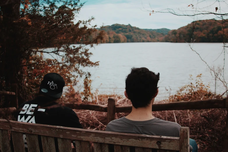 two people looking out over the lake on the bench