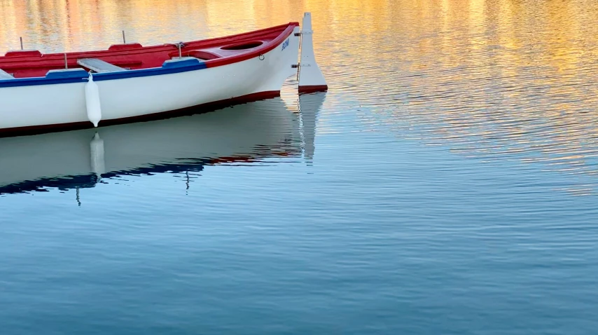 a small boat floating on top of a lake