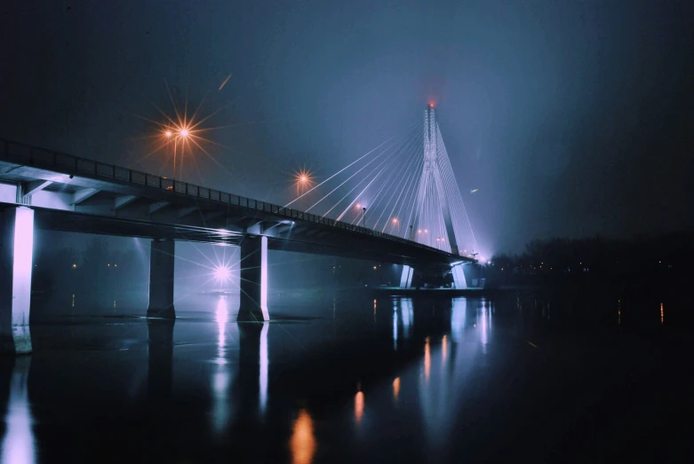 a bridge that has lights on it near water