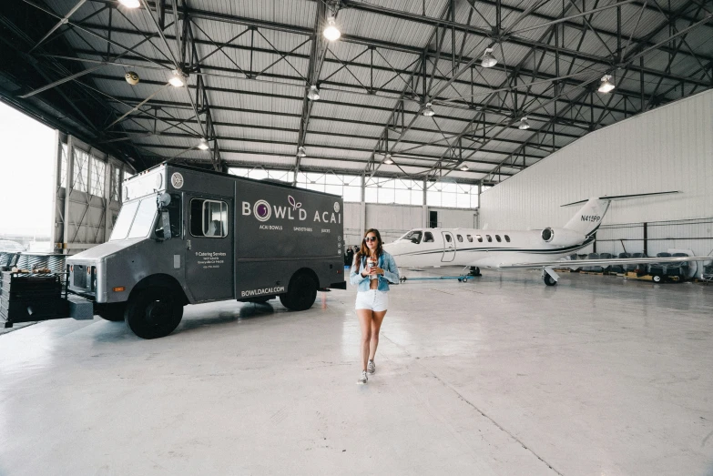 a person standing in a hanger in front of an airplane