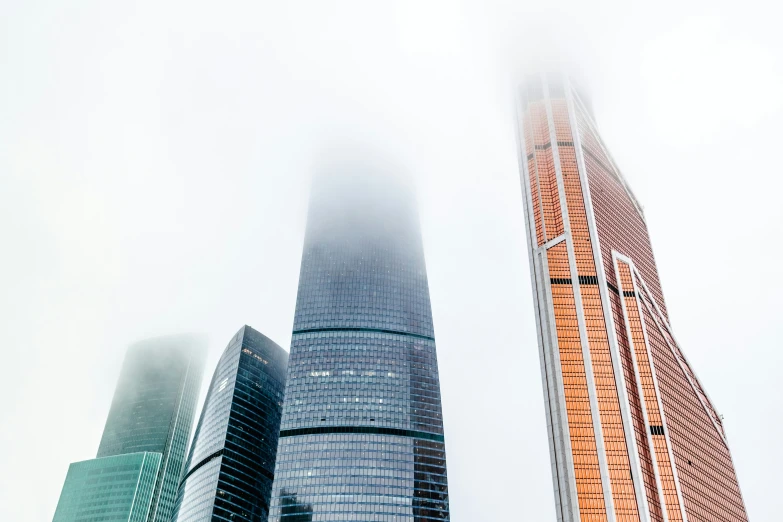 tall skyscrs standing in the fog on a cloudy day