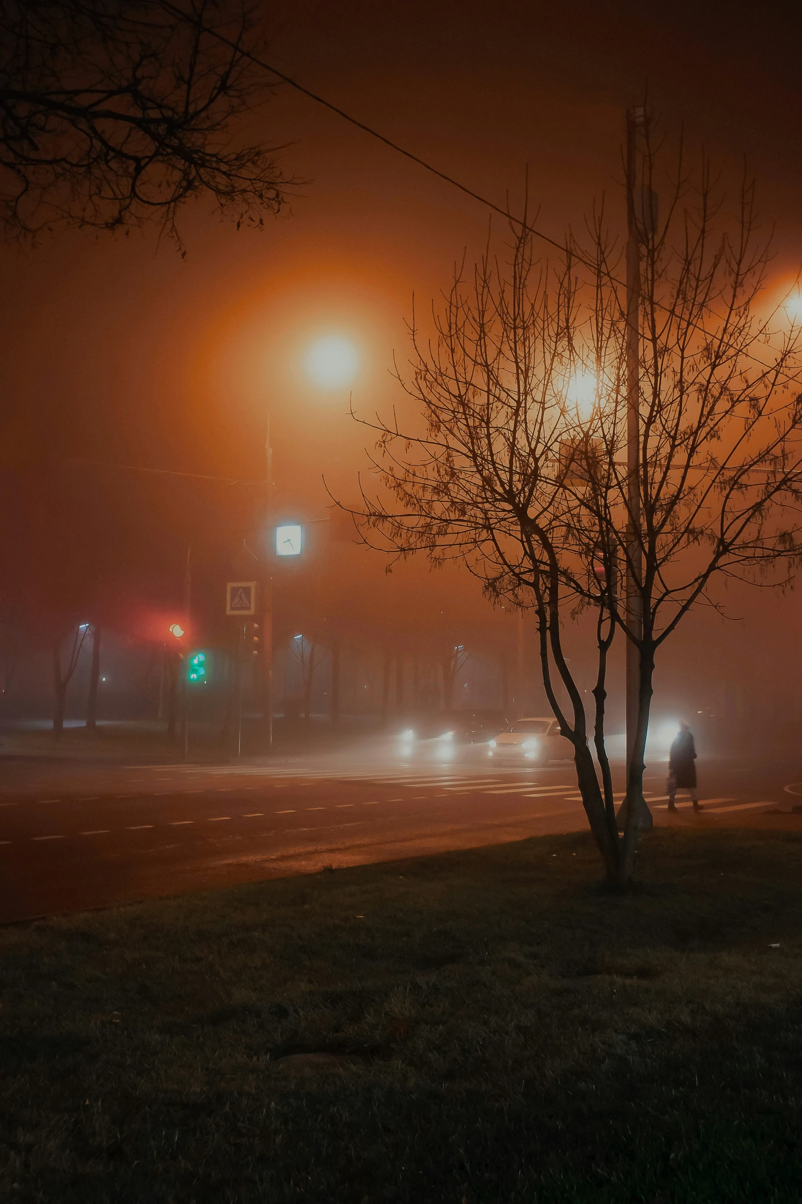 fog is coming in over an intersection with traffic lights on