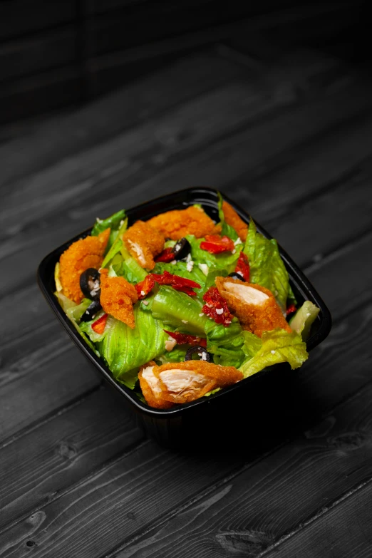 some food in a small container on a wooden table