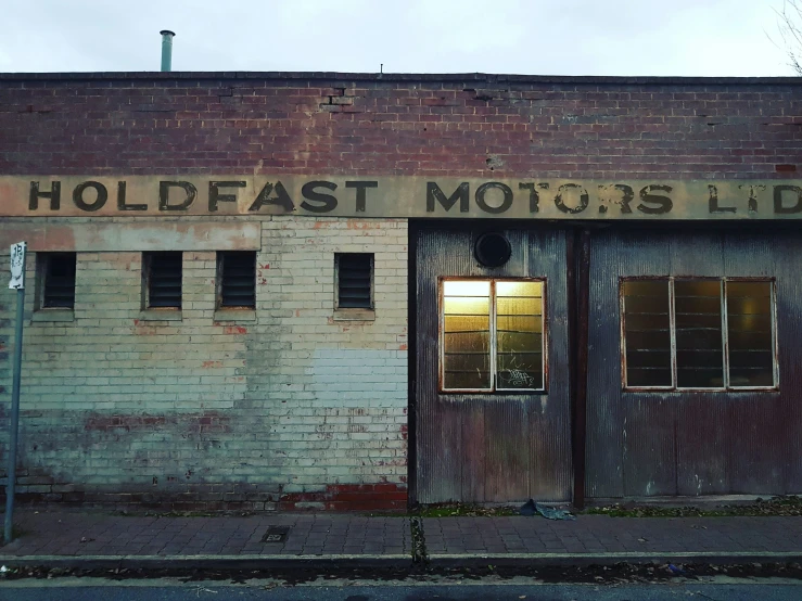 a brick building with old painted garage doors