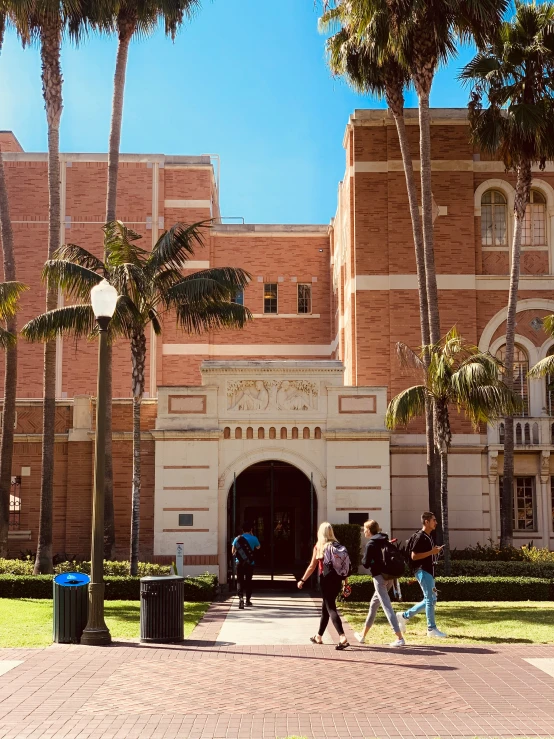 a large pink building with palm trees surrounding