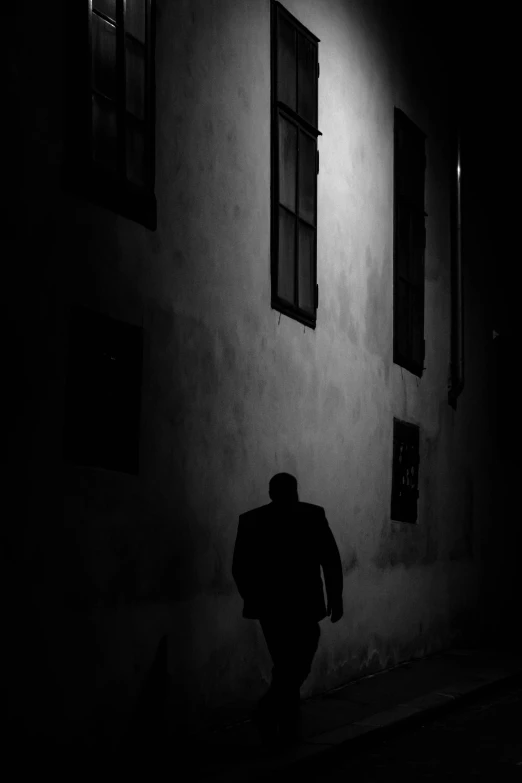 black and white po of a man standing in front of a building