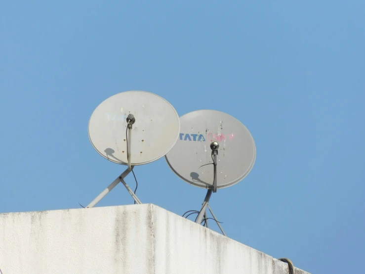 two satellite dishes on top of a building