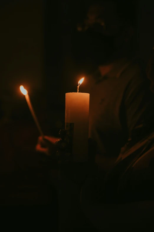 a person holding up a candle in a dark room