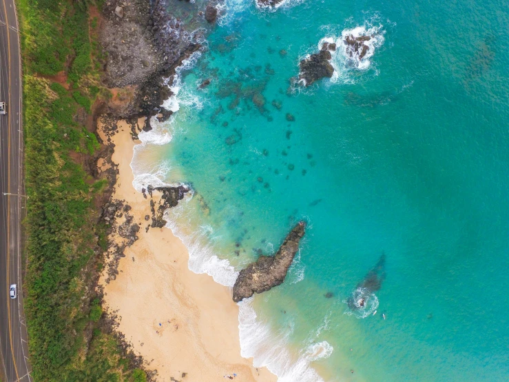 an aerial view of a long sandy beach next to the ocean