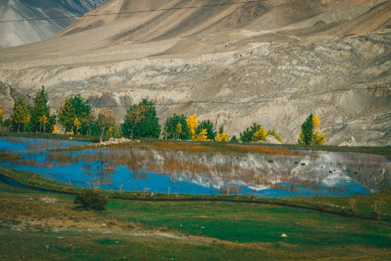 the mountains surrounding the pond are reflected in the still water