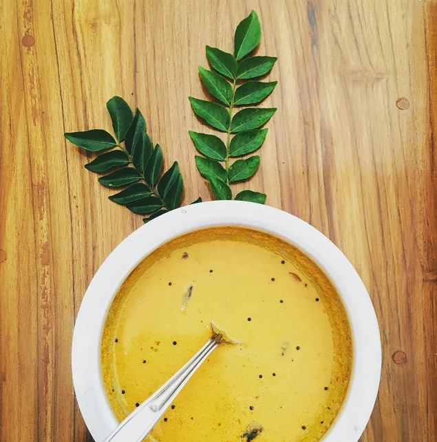 a bowl of soup with two silver forks on top