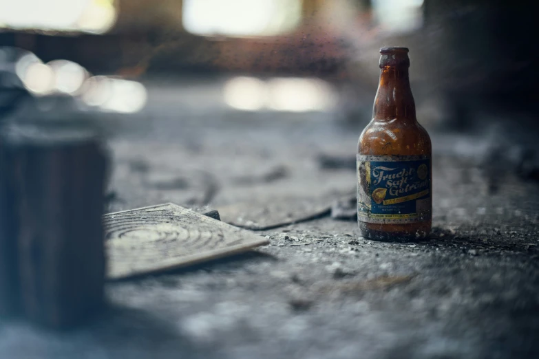 a close up view of a beer bottle on the ground
