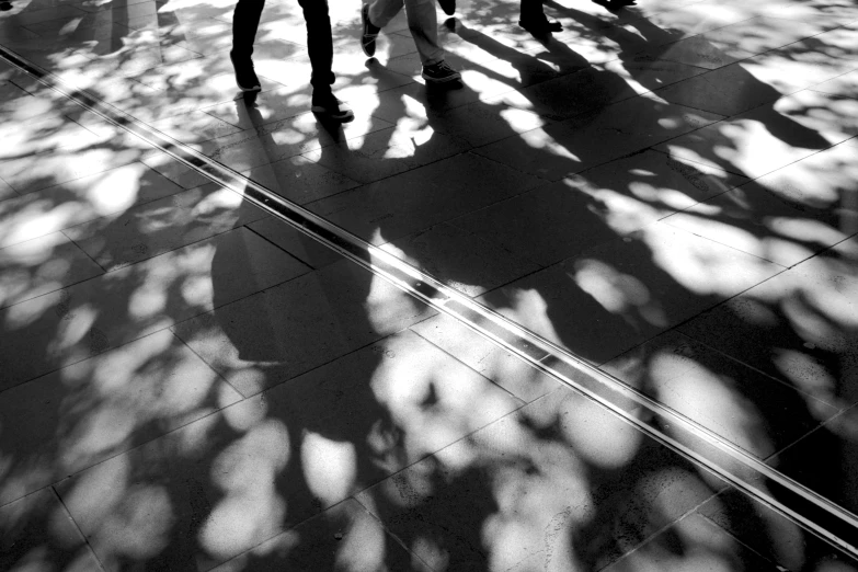 black and white po of three people with backpacks and a cell phone