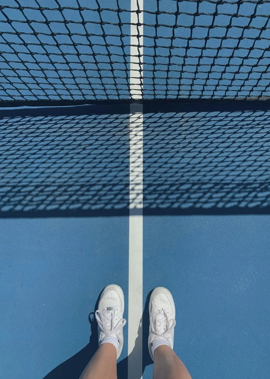 a person standing at the top of a tennis court