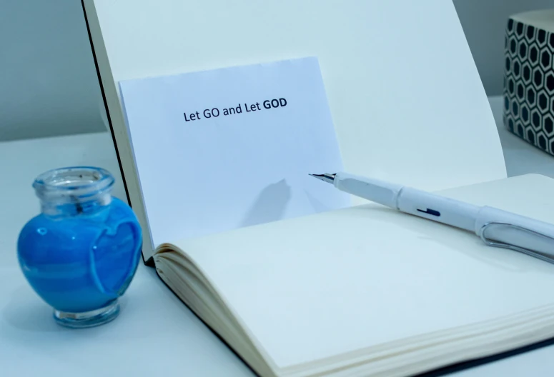 a pen resting on top of a book next to a pen