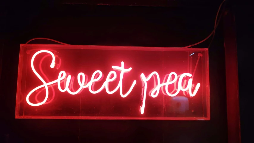 a red neon sign advertising sweet pea