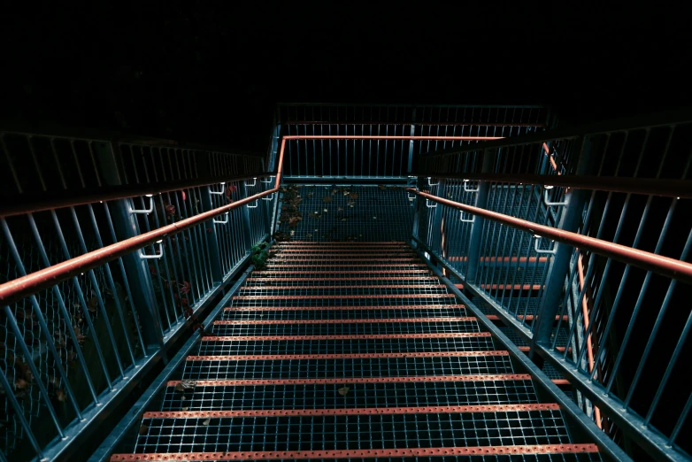 a stair leading down from a metal bridge
