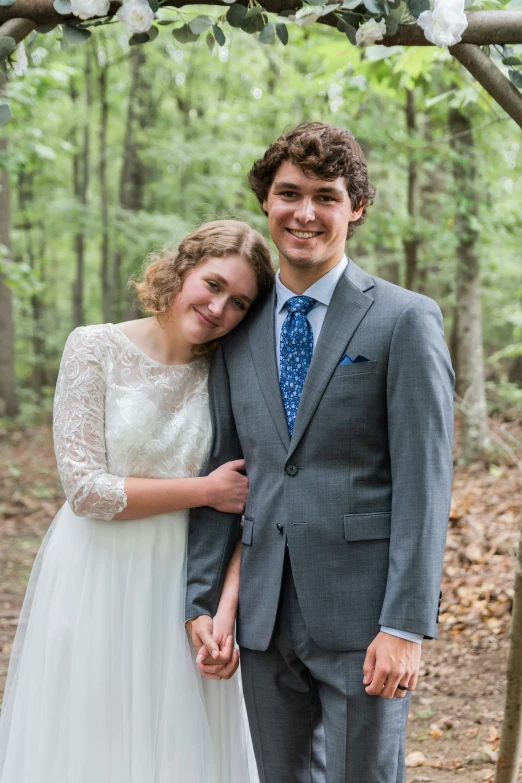 young couple posing under arbors for their wedding pos