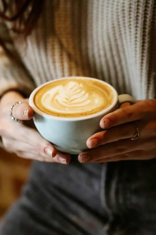 a woman holding up a cup of coffee