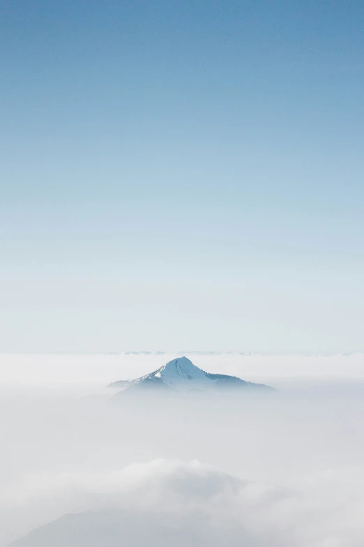 an ocean of fog in the distance with a distant mountain