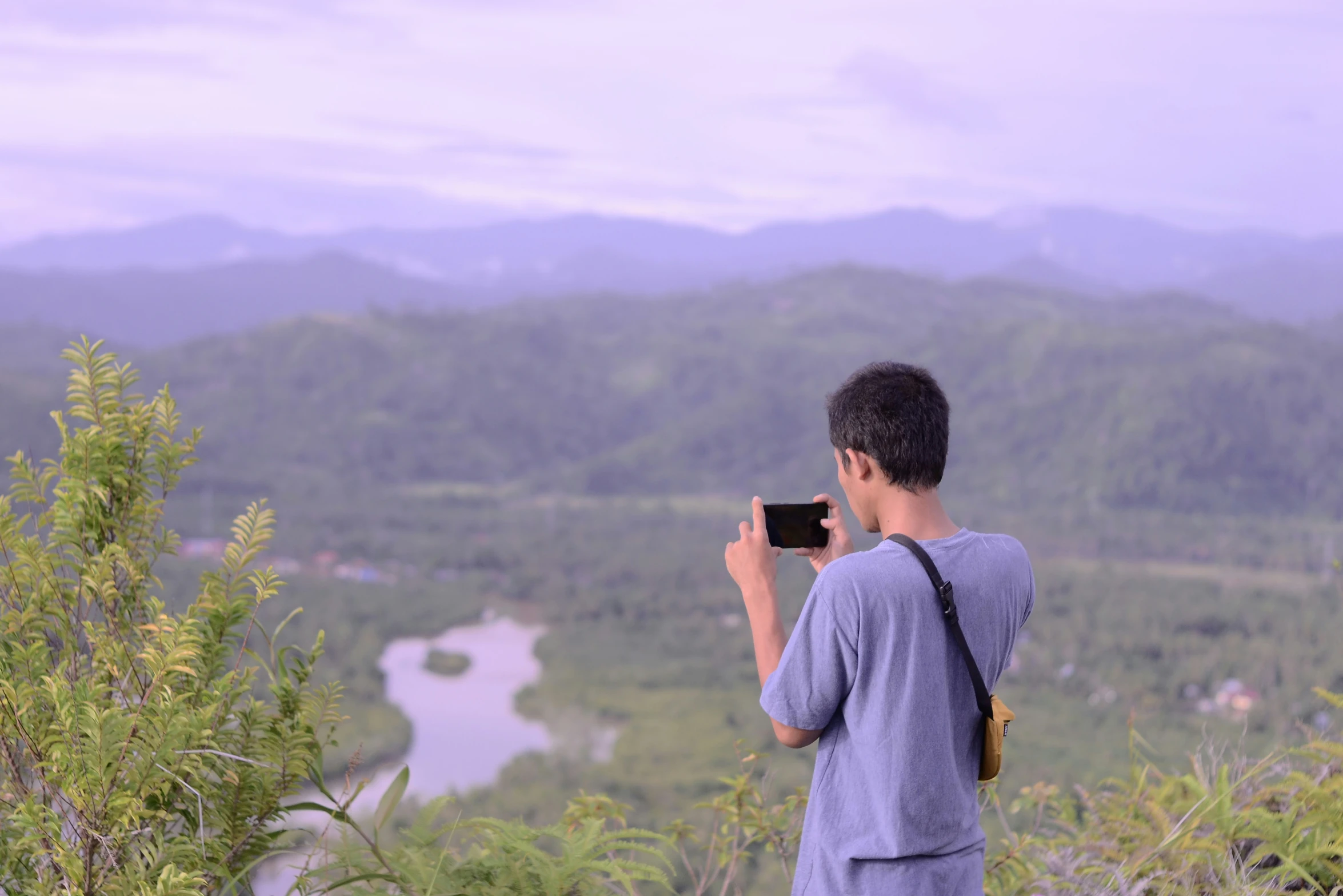 a man is taking a picture of the scenery with his cell phone