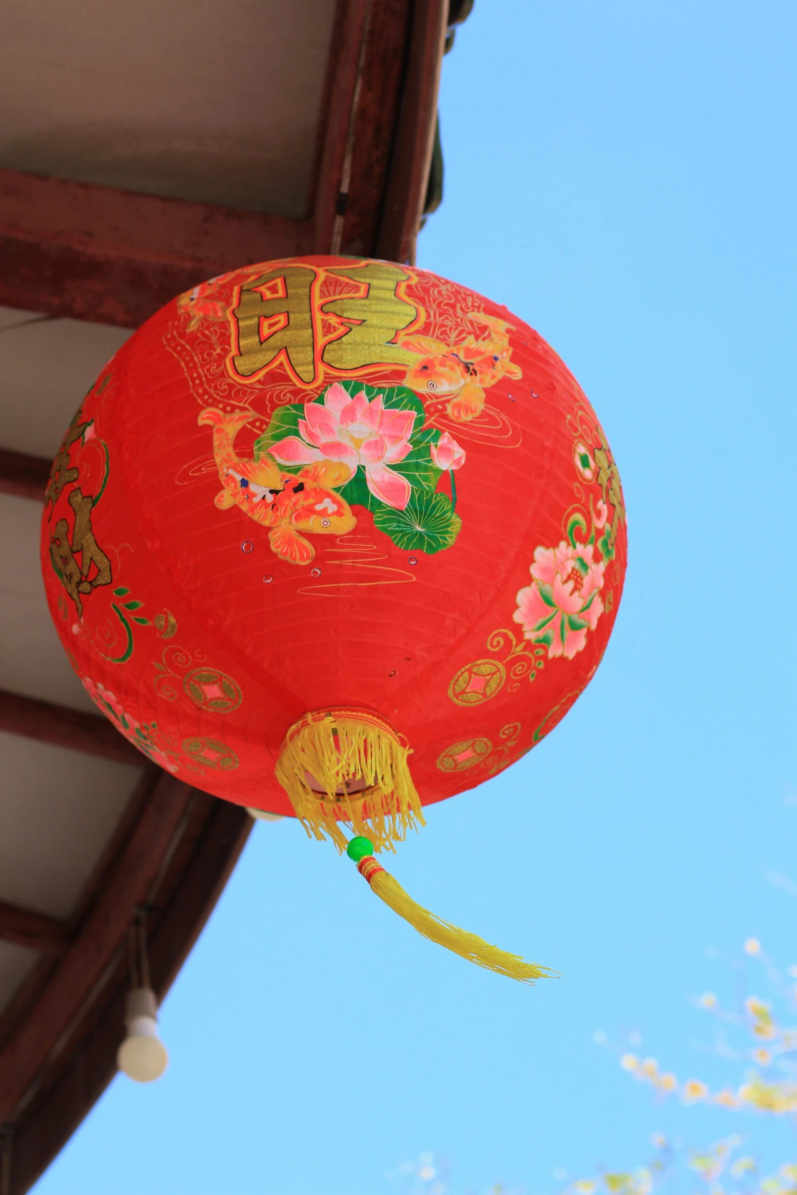a red paper lantern on a roof against a blue sky