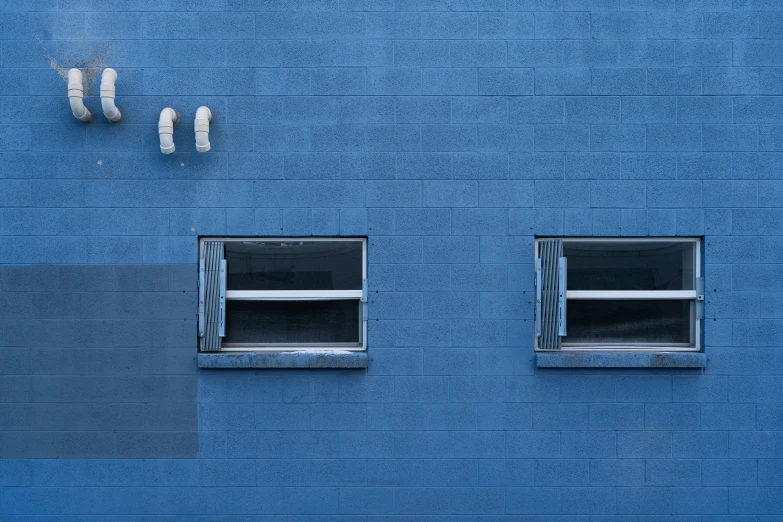 two open windows on a blue wall and three smaller ones next to them