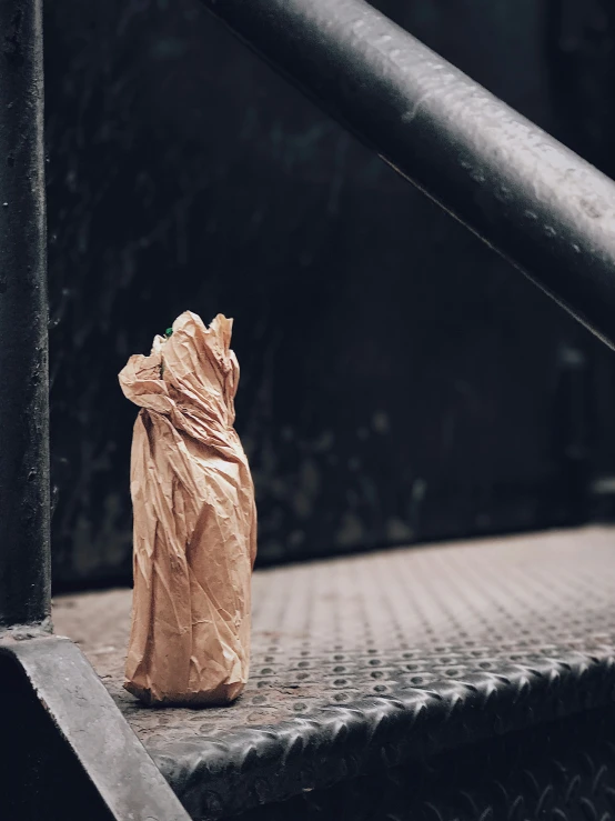 a brown bag sits on the side of some steel railing