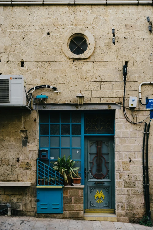 a brick building with a blue door and air conditioning unit