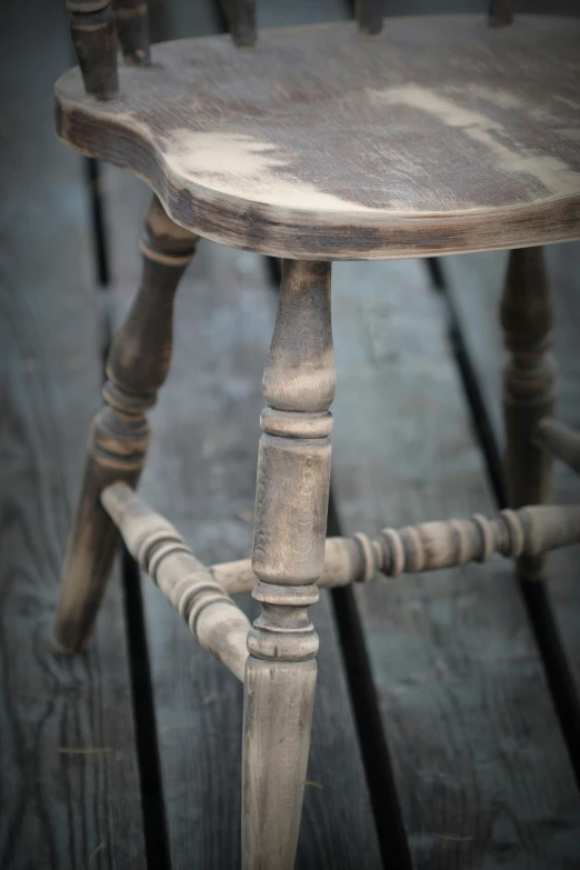 a wooden chair with a white paint covered seat