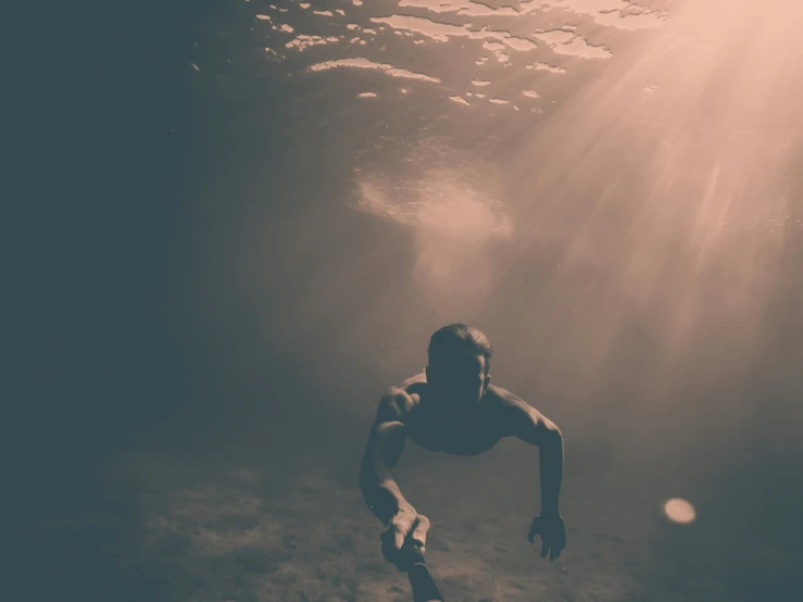 a man swimming under water near an ocean