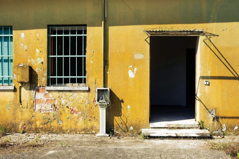 a yellow building with several windows and some bars