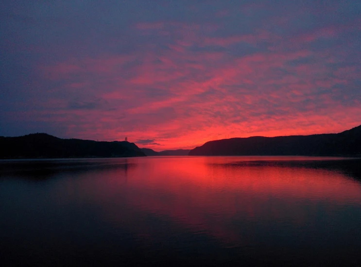 this sunset has pink clouds over the mountains