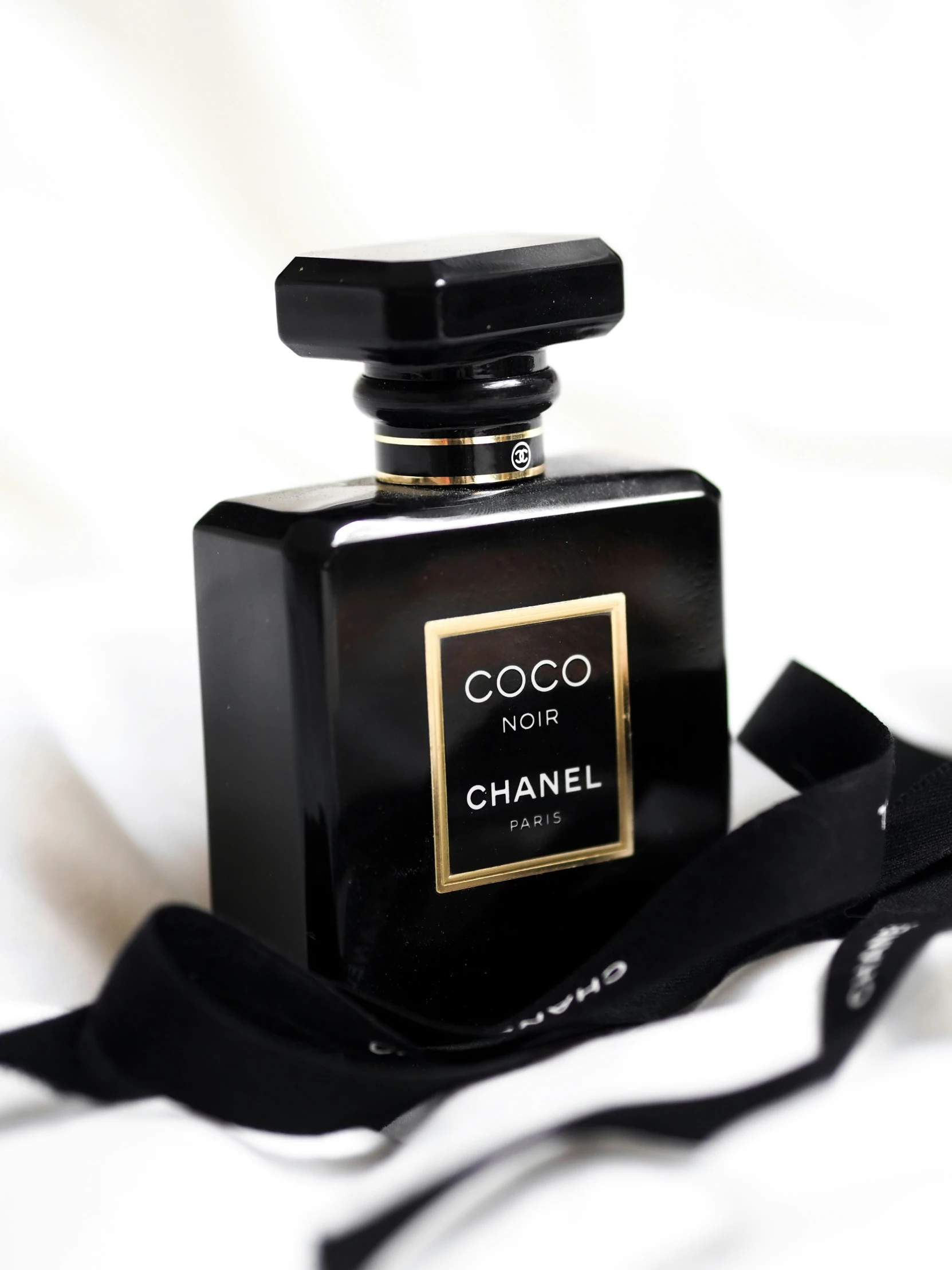 a chanel bottle on a white bed spread