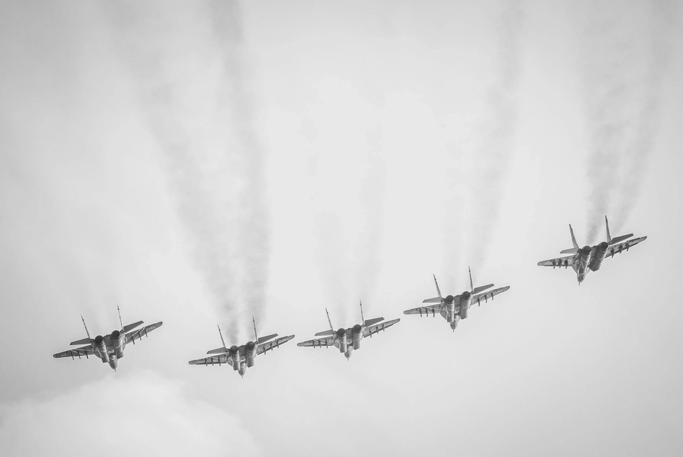 four jets fly in formation into the sky