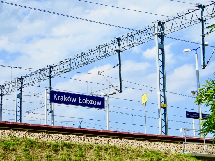 a blue street sign on a steel line