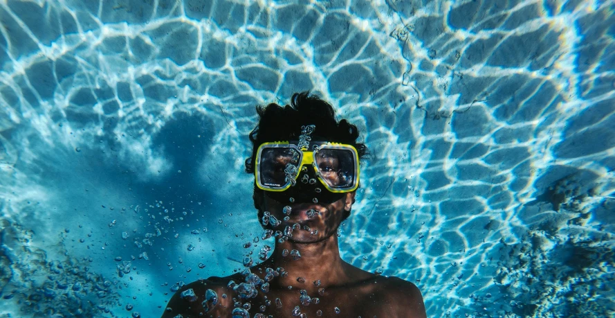 the man wearing glasses is standing in the pool