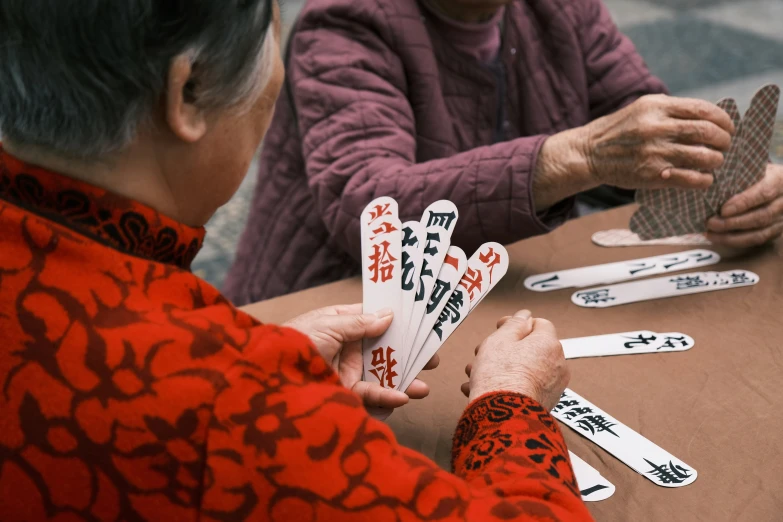 two women holding cards at a table