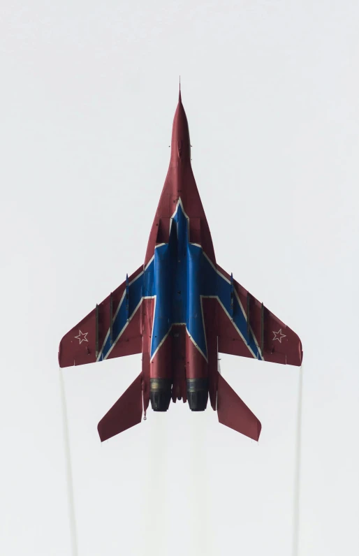a red and blue jet airplane flying upside down